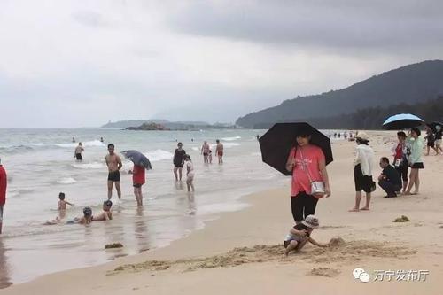 中國僑網(wǎng)游客嬉戲于海邊。