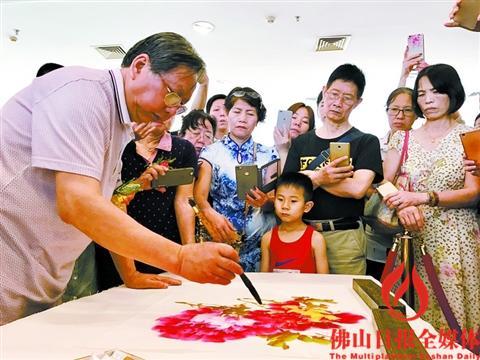 中國僑網(wǎng)國畫名家陳永康現(xiàn)場畫牡丹,,引市民圍觀,。