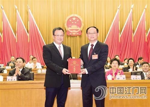 中國僑網(wǎng)市委書記,、市人大常委會主任林應(yīng)武代表大會主席團為新當選的市長劉毅頒發(fā)當選證,。江門日報記者 周華東 攝