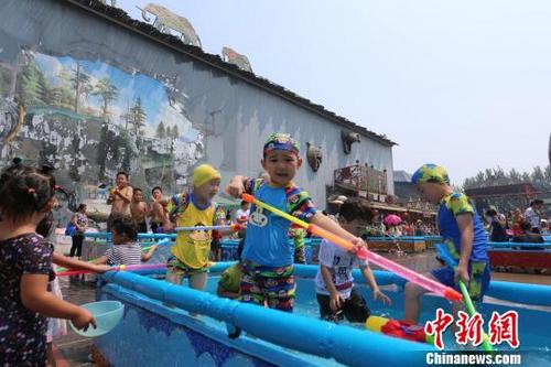 中國(guó)僑網(wǎng)第三屆呀路古潑水狂歡季今天在北京呀路古熱帶植物園開(kāi)幕,。圖為孩子們?cè)跐娝?jié)中享受夏日清涼,?!£惷鳌z