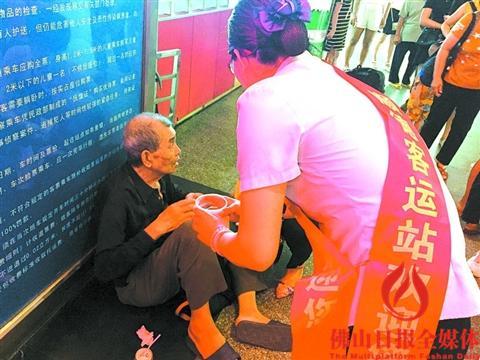 中國(guó)僑網(wǎng)工作人員在旁邊照料老人,。(區(qū)嘉燕 攝)
