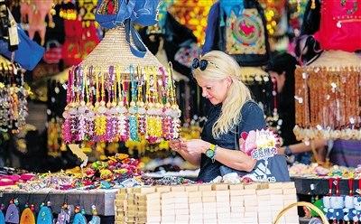 中國僑網(wǎng)外國游客在三亞一家商店內(nèi)選購旅游產(chǎn)品,。本報記者 武威 攝