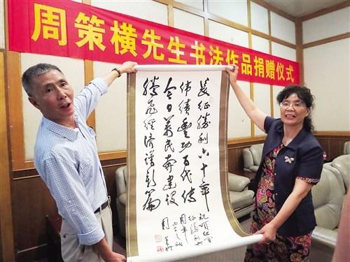 中國僑網(wǎng)周建虎向廣西博物館捐贈父親周策橫的書法作品 本報記者 賴有光攝