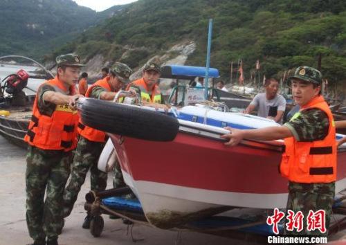 中國僑網(wǎng)圖為邊防官兵幫民眾轉移船只,。王華 攝