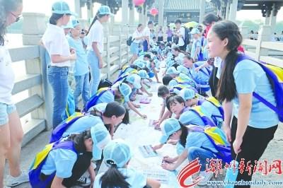 中國僑網(wǎng)22日下午,,參加福彩夏令營的小朋友們在廣濟橋上以“六城同創(chuàng)”“治六亂”為主題繪制長卷,。 本報記者 陳翊 攝