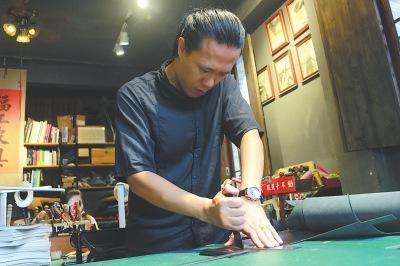 中國(guó)僑網(wǎng)何巍正在給皮具原料裁邊,。