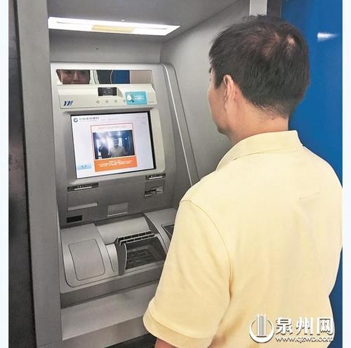 中國僑網(wǎng)銀行工作人員演示刷臉取款流程