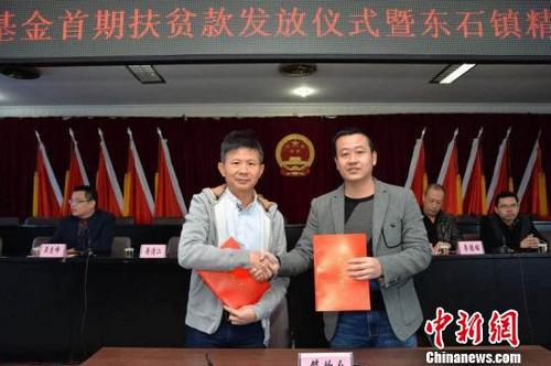 中國(guó)僑網(wǎng)愛心企業(yè)家蕭清江(左)出資100萬元成立“扶貧基金”,,圖為東石鎮(zhèn)政府與其簽訂協(xié)議書,?!∨PФY 攝