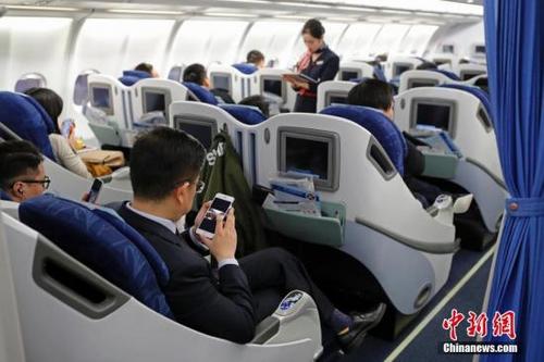 中國僑網(wǎng)資料圖:在東航MU5137航班上,,旅客全程在飛行模式下可以使用手機(jī),。殷立勤 攝