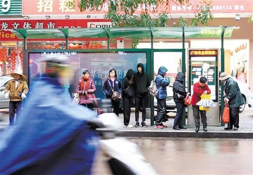 中國(guó)僑網(wǎng)公交站臺(tái),在寒風(fēng)中的市民盼著公交車快點(diǎn)到來(lái),。
