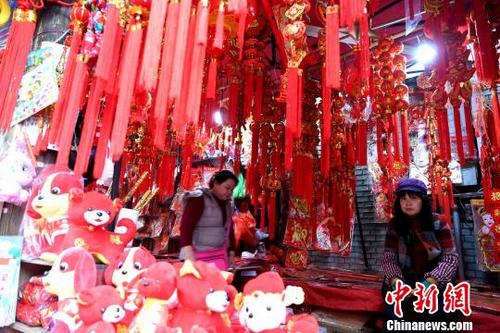 中國僑網(wǎng)賣年貨的老板正在等待顧客,?!⊥鯑|明 攝