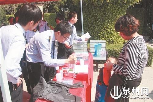 中國僑網(wǎng)工作人員對市民帶來的井水進行檢測