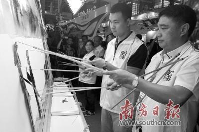 中國僑網(wǎng)蔡勁筍(右一)在文博會主會場大鵬展區(qū)表演皮影戲,。 南方日報記者 朱洪波 攝