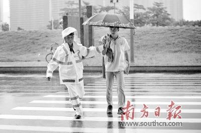 中國僑網(wǎng)佛山三中高中部考點,交警護(hù)送考生穿過馬路,。本版圖片均為南方日報記者 戴嘉信 攝