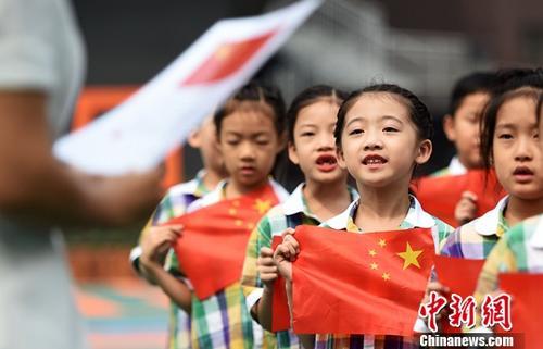 中國僑網(wǎng) 資料圖:小學(xué)生在老師的指導(dǎo)下齊唱國歌。中新社記者 翟羽佳 攝