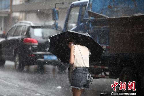中國僑網(wǎng)圖為民眾頂著風(fēng)雨前行?!∶系慢垺z
