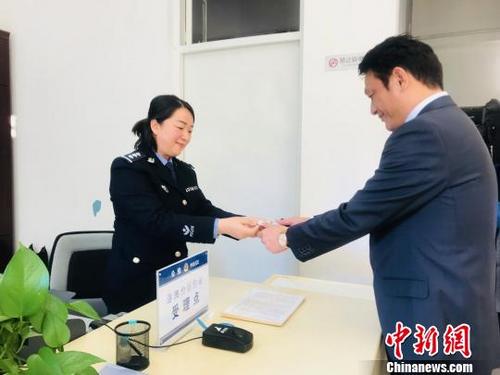 中國僑網(wǎng)派出所工作人員向?qū)幭呐_胞投資企業(yè)協(xié)會會長李京安發(fā)放臺灣居民居住證,。 額麗其格 攝