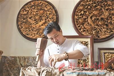中國僑網(wǎng)盧進(jìn)文在制作木雕,?! ”緢笥浾?莊園 攝