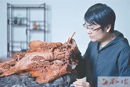 中國(guó)僑網(wǎng)圖為林建軍正在進(jìn)行木雕創(chuàng)作,。