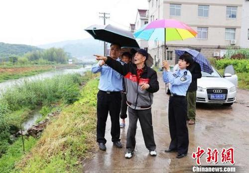 中國僑網(wǎng)圖為:民警陪臺胞蔣志凡尋找其父親86年前的安葬地 仙居公安供圖