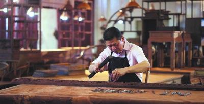 中國僑網(wǎng)已經(jīng)是深夜了,,黃福華還在雕刻作品,。