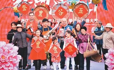 中國僑網(wǎng)國際友人與青田本地村民共同參演國際村晚節(jié)目《豐收的記憶》(《人民日報海外版》/黃玲曉文 張永益攝)