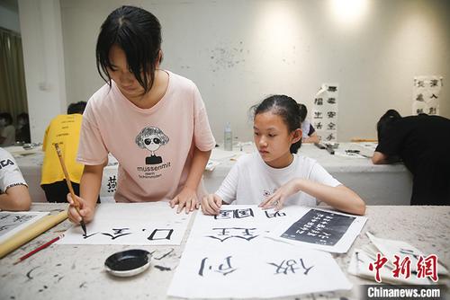 中國僑網(wǎng)圖為6月13日,,年輕人在水藤村紅基石黨群服務(wù)中心內(nèi)學(xué)習(xí)書法,。 中新社記者 王駿 攝