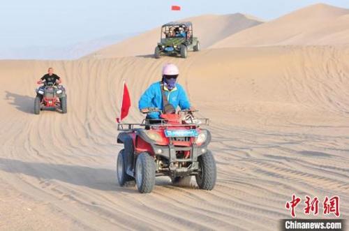 中國僑網(wǎng)游客乘坐沙漠越野車載沙海沖浪。王斌銀攝