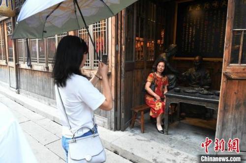 中國僑網游客在古厝里與反映老福州生活場景的雕塑合影留念,。王東明攝
