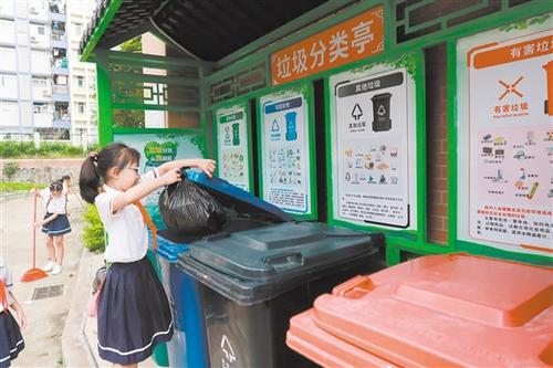 中國(guó)僑網(wǎng)農(nóng)林雙朗小學(xué)學(xué)生將垃圾投放到垃圾分類收集點(diǎn),。