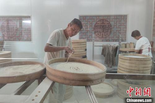 中國(guó)僑網(wǎng)在來(lái)旺良品堂閩南古早味傳承基地,,游客透過(guò)透明的櫥窗,,可以觀(guān)看手工面線(xiàn)等美食的制作流程。 吳冠標(biāo) 攝