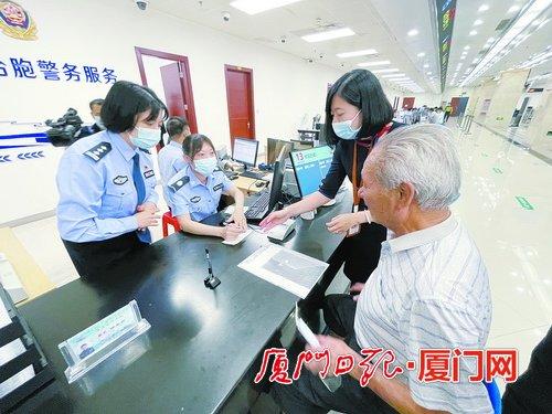中國僑網(wǎng)集美公安分局民警在現(xiàn)場耐心地為臺胞辦理證件。(本報(bào)記者 薛堯 攝)