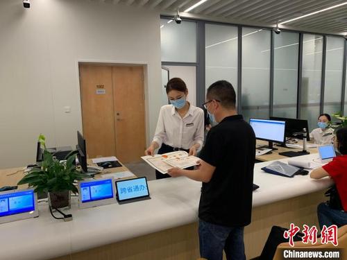 中國僑網(wǎng)圖為:市民正在辦理證件,?!∮握裨乒﹫D