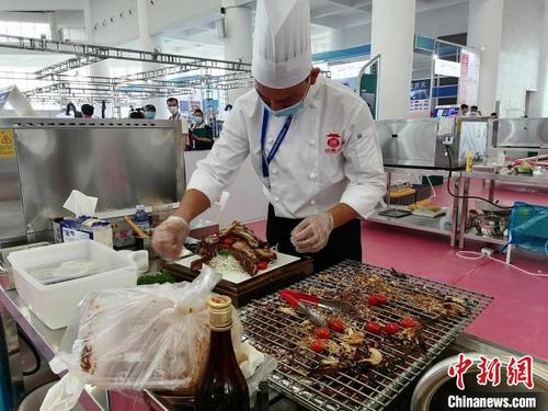 中國僑網(wǎng)羊肉烘烤選手在比賽中,。梁盛 攝