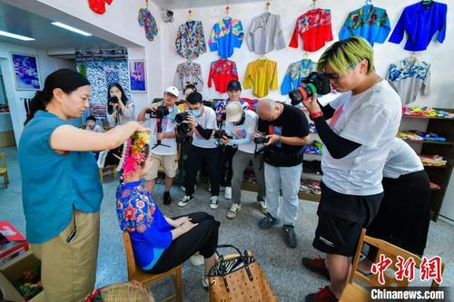 中國僑網(wǎng)在泉州市豐澤區(qū)蟳埔漁村體驗非遺盤發(fā)手藝,?!∪菸穆镁止﹫D