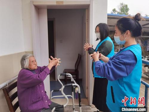 中國僑網(wǎng)支老人員教老人做手指操。 倪妮 攝