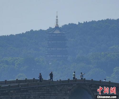 中國僑網(wǎng)圖為:游客在西湖錦帶橋游覽,?!⊥鮿偂z