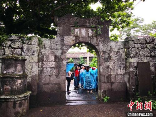 中國(guó)僑網(wǎng)圖為中國(guó)傳統(tǒng)村落??谑腥浯?,游人參觀三卿村“豪賢門”?!∫C鳌z