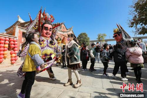中國僑網(wǎng)“電音三太子”演員與小朋友互動玩耍?!≠囘M財 攝