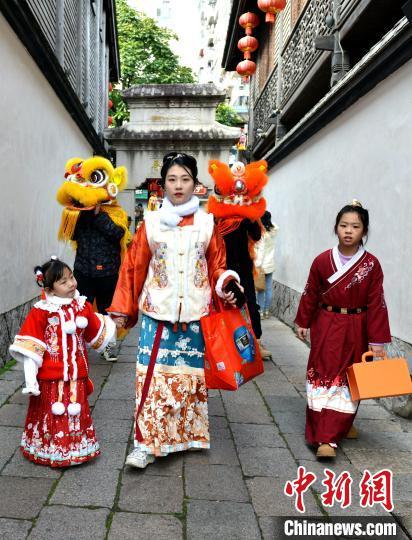 中國僑網(wǎng)“迎財神”隊伍在福州三坊七巷巡游送祝福?!蚊鳌z