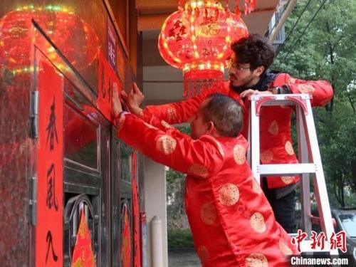 中國僑網(wǎng)義烏雞鳴山社區(qū)外籍居民貼春聯(lián),。董易鑫攝