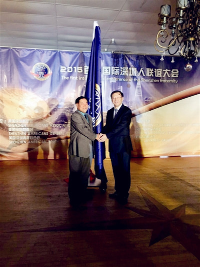 馬勇智(右)為首屆國(guó)際深圳人聯(lián)誼大會(huì)授旗,。