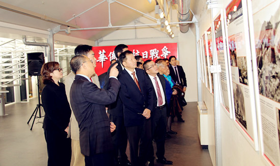 中國駐法使館領(lǐng)事部主任李平公參在歐洲時報社長張曉貝、副社長陳曉燕陪同下與僑領(lǐng)一起觀看圖片,。(黃冠杰