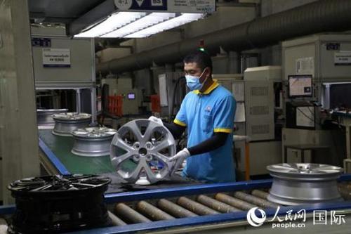 中國僑網(wǎng)新泰車輪公司積極發(fā)展屬地化,泰國員工達(dá)80%以上,。圖為泰籍員工在汽車輪胎生產(chǎn)線上工作,。人民網(wǎng)記者孫廣勇攝