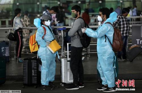中國僑網(wǎng)5月25日,,在印度孟買希拉吉國際機(jī)場,,旅客們穿戴著防護(hù)服和面罩出行,。 印度政府允許國內(nèi)航線自5月25日起恢復(fù),。