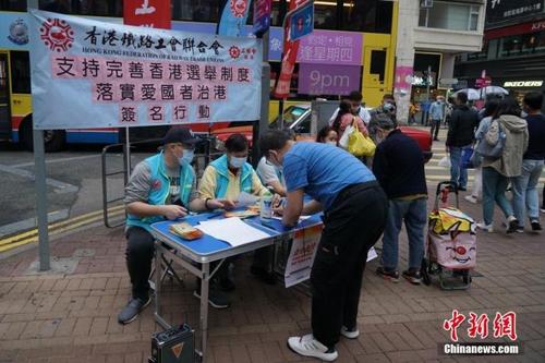 中國僑網(wǎng)3月6日,,香港灣仔街頭,,市民在香港工聯(lián)會街站簽名,,支持完善香港選舉制度,,落實“愛國者治港”。中新社記者 張煒 攝
