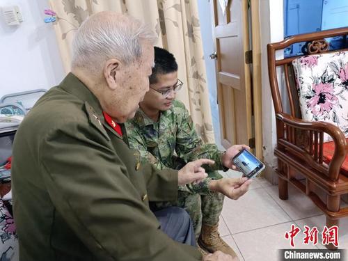 中國(guó)僑網(wǎng)漳州干休所文職人員莊松海陪同抗美援朝老兵劉榮洪觀看直播?!≌闹菔型艘圮娙耸聞?wù)局供圖