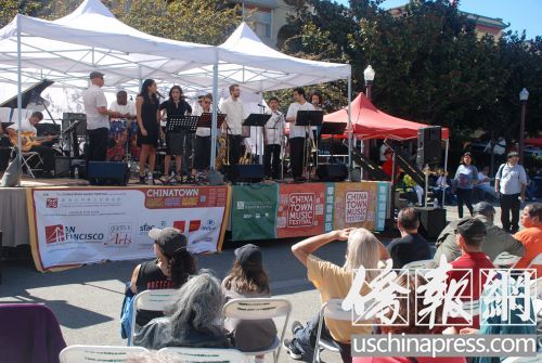 人們頂著烈日驕陽聽歌唱表演,。(美國《僑報》/吳卓明