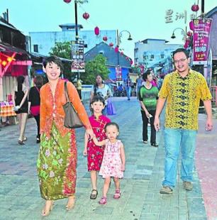 中國僑網(wǎng)一對夫妻穿著峇迪上衣及歌峇雅帶著孩子出席旅游節(jié),。(馬來西亞《星洲日報》)