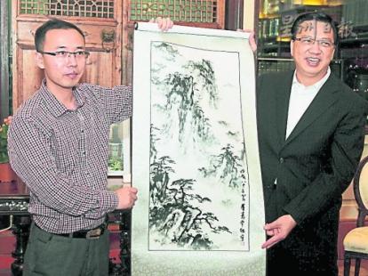 中國僑網(wǎng)毛春華(左)贈送紀(jì)念品給廖中萊,。(馬來西亞《星洲日報》)